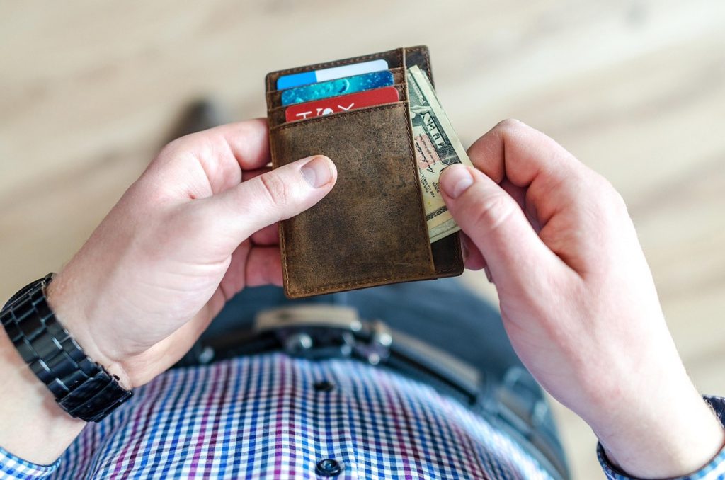 A person holding a wallet filled with payment cards