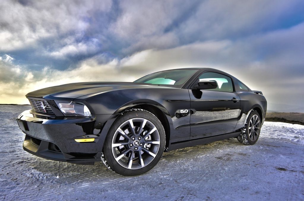 A modern car parked outdoors under a cloudy sky